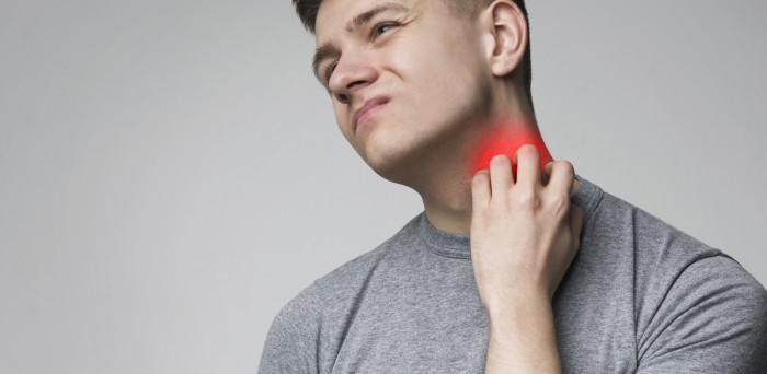 Young man scratching his itchy neck with allergy rash